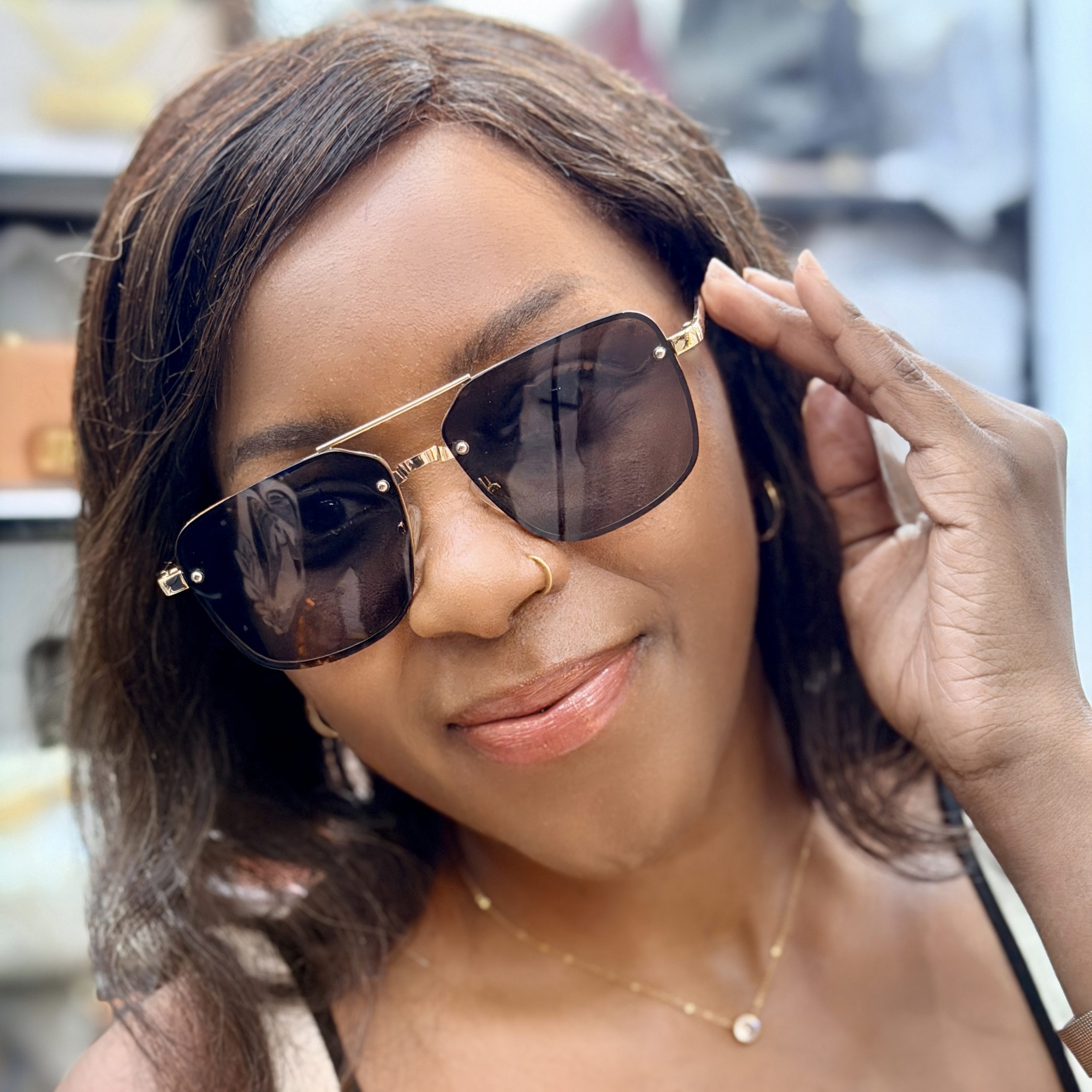 Woman wearing sunglasses with metallic rims.