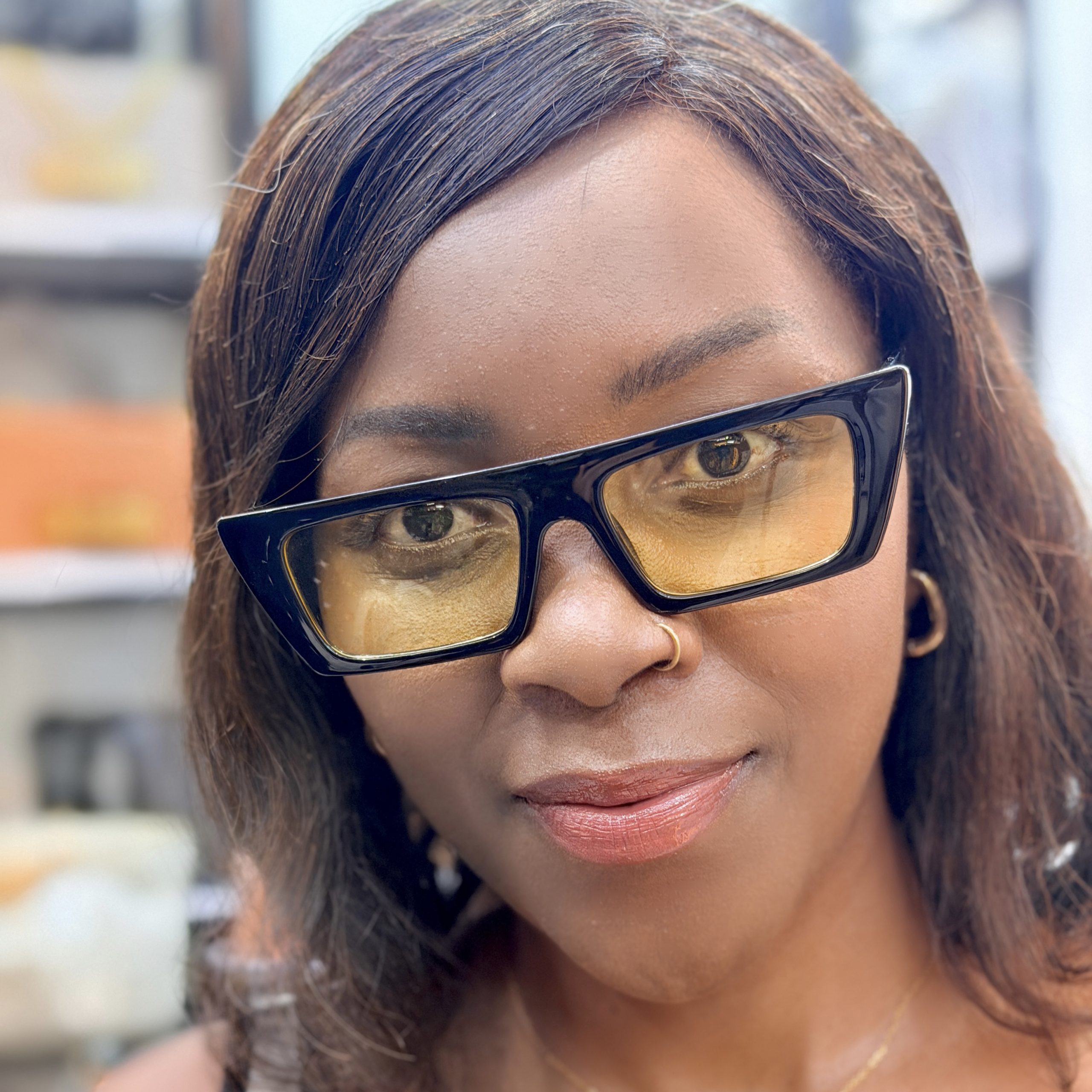 Lady wearing a pair of yellow tinted sunglasses.