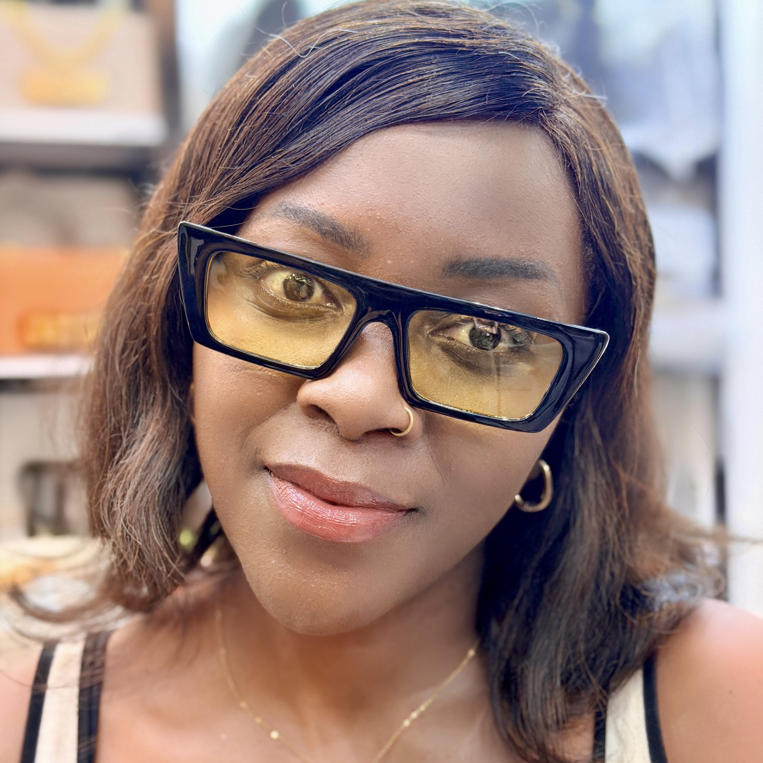 Woman wearing yellow tinted sunglasses.