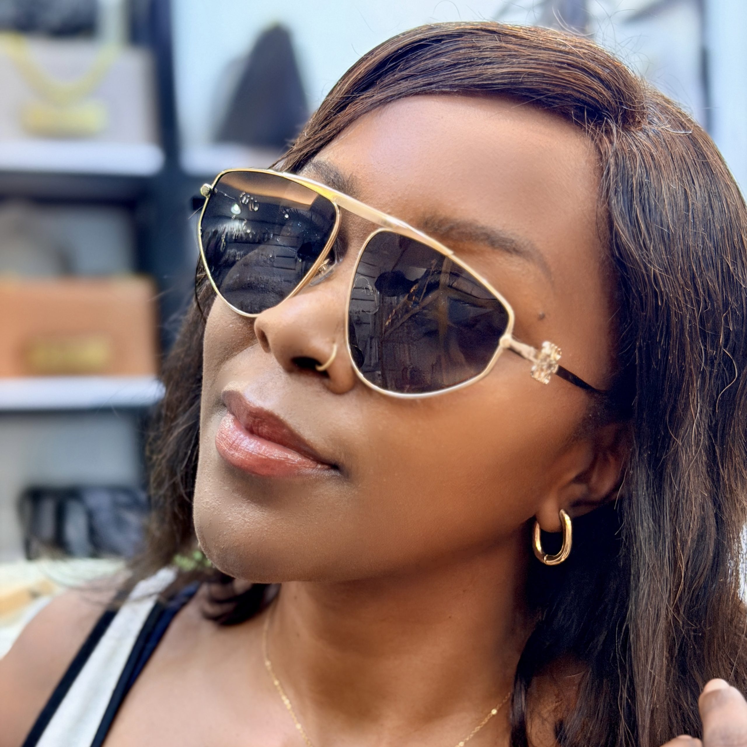 Woman wearing sunglasses with metallic rims.
