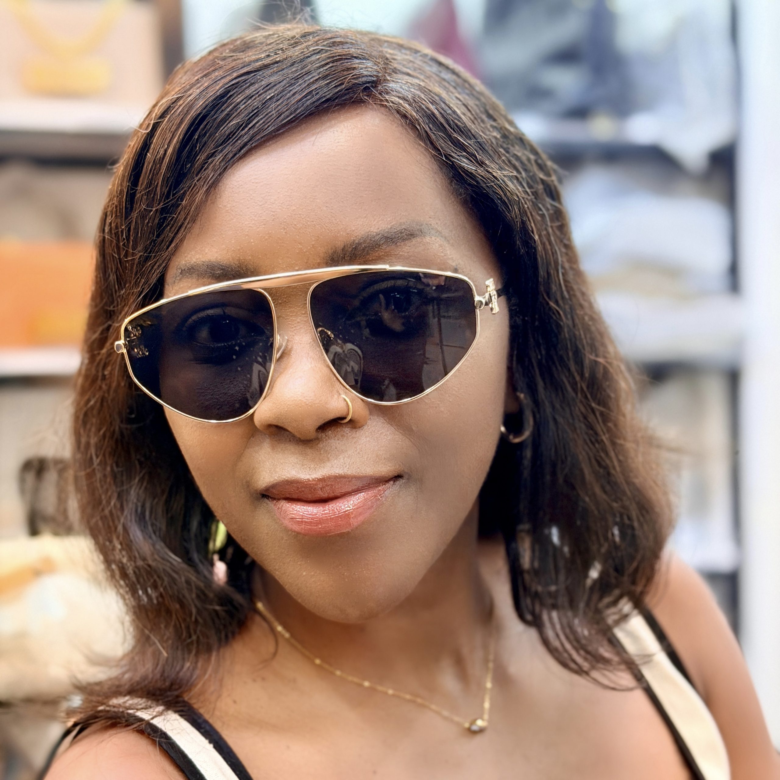 Woman wearing sunglasses with metallic rims.