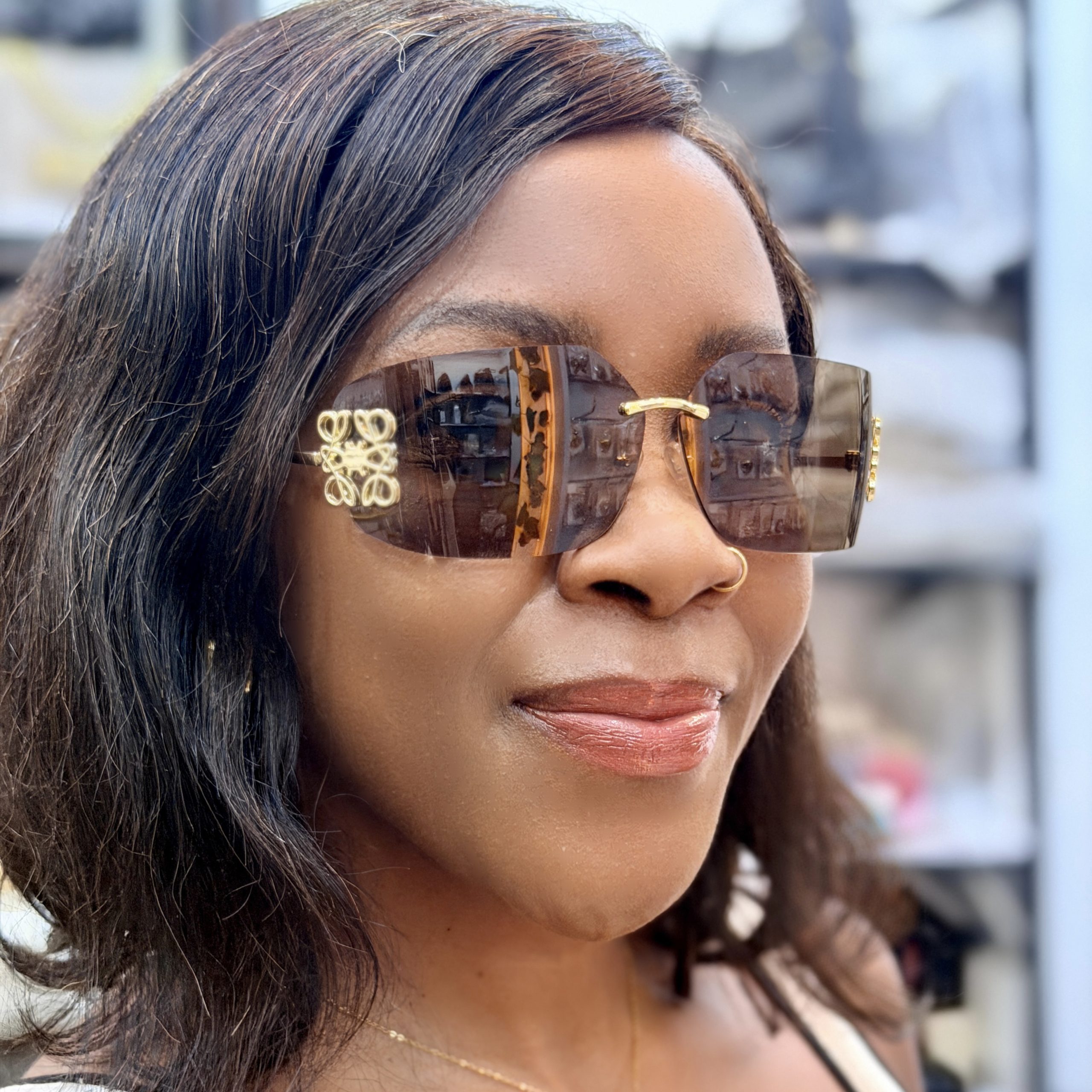 Woman wearing brown rimless sunglasses.