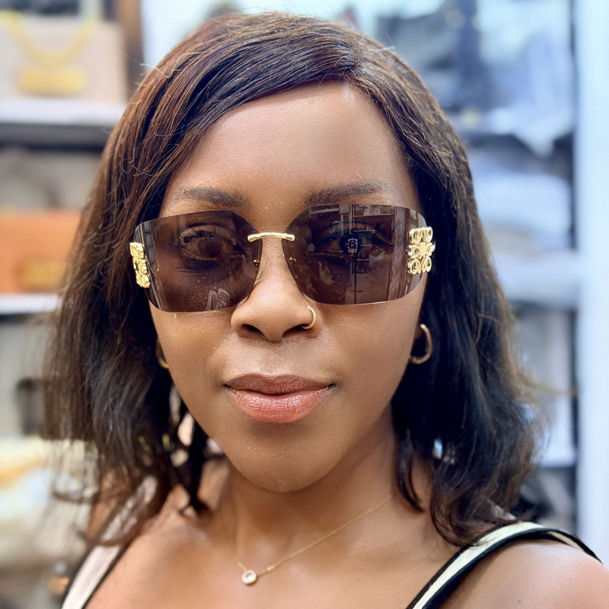 Woman wearing brown rimless sunglasses.