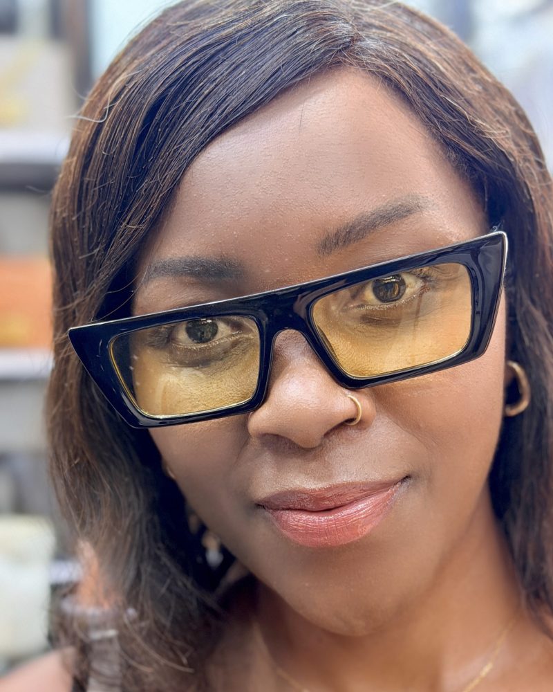 Lady wearing a pair of yellow tinted sunglasses.