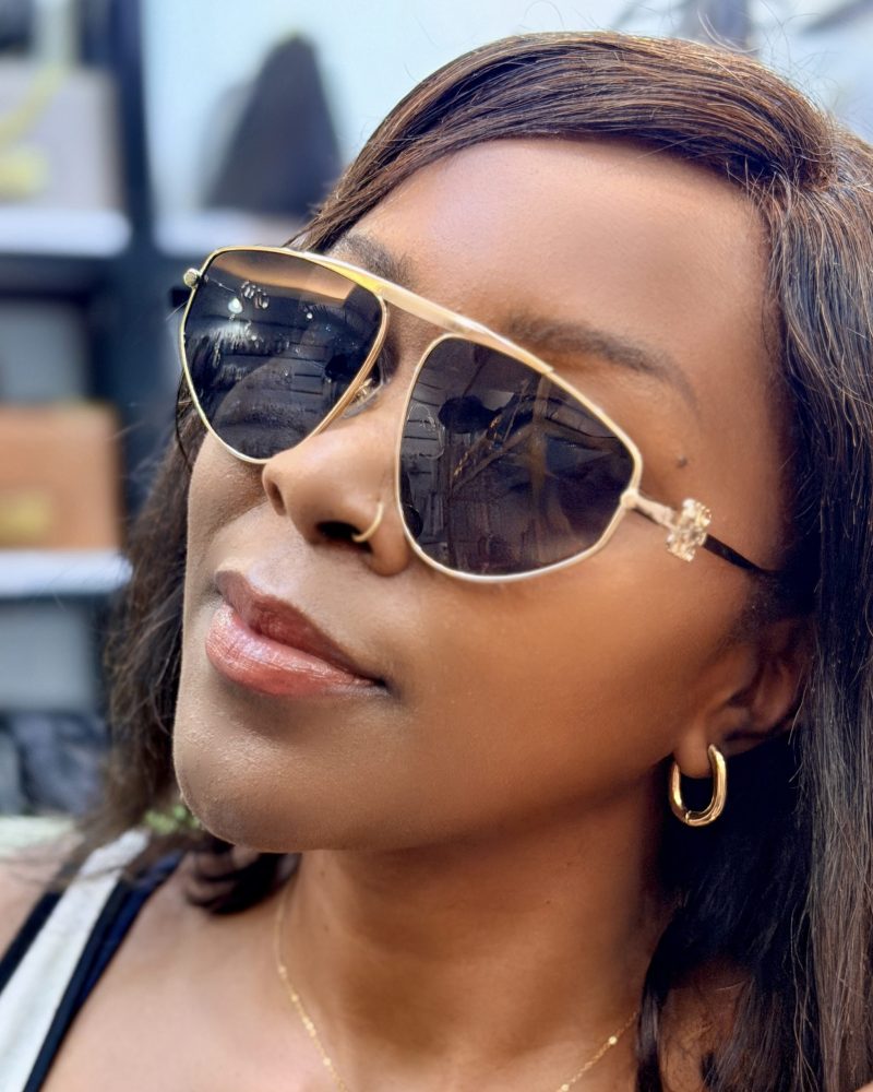 Woman wearing sunglasses with metallic rims.