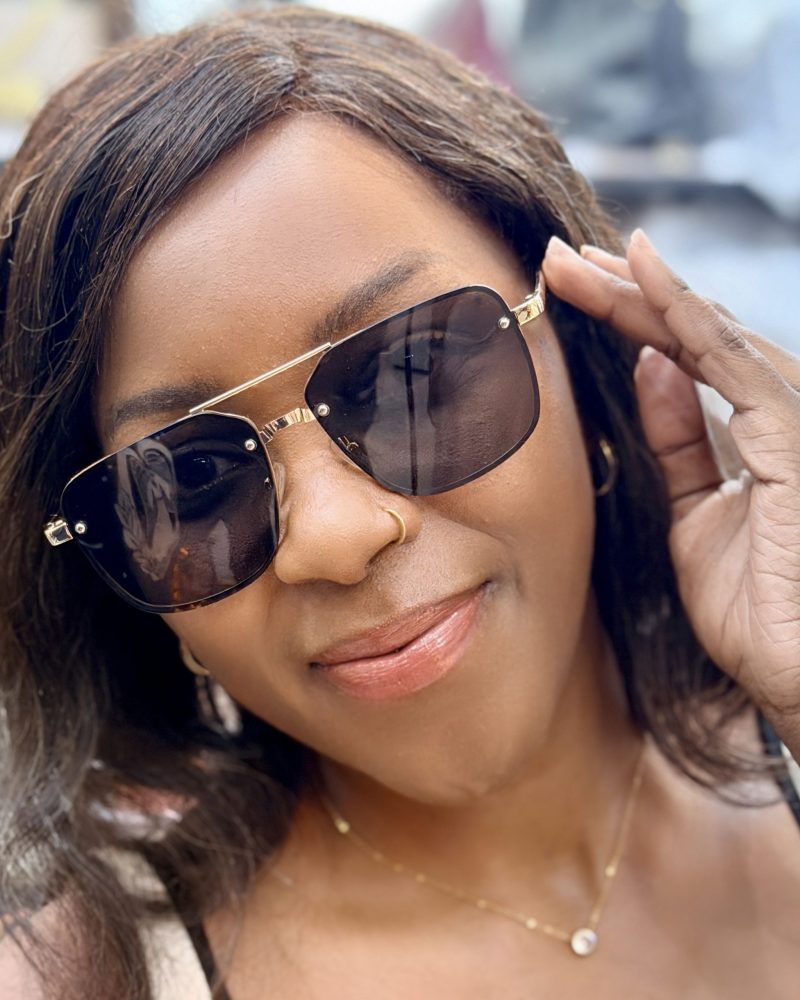 Woman wearing sunglasses with metallic rims.