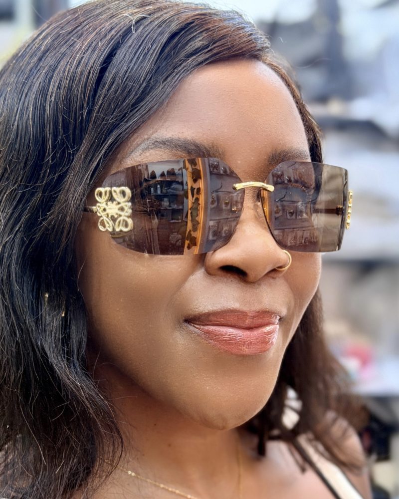 Woman wearing brown rimless sunglasses.